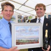 RNS Art Exhibition head steward Tom Cringle and Guy Gowing from Arnolds Keys with the winning picture 500px